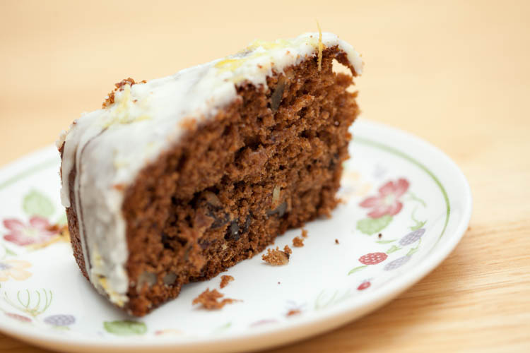 A slice of Iced Date & Walnut Cake on a plate